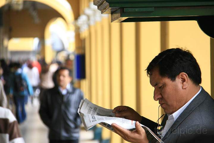 sa_pe_lima_004.jpg - Ein Geschäftsmann liest Zeitung während er die Schuhe geputzt bekommt